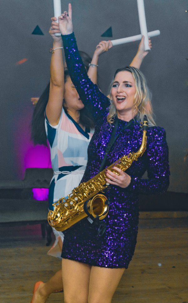 Clare DJing and playing sax at an event