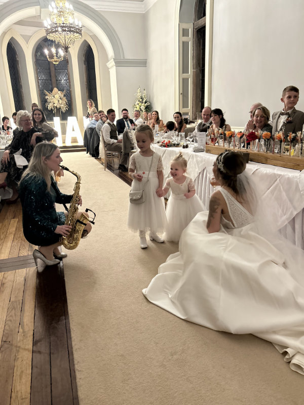 Clare playing the saxophone with bridesmaids